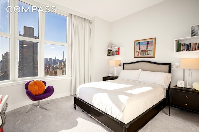 bedroom with baseboards, carpet, and a view of city