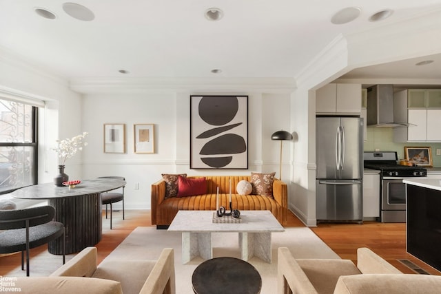 living room featuring light hardwood / wood-style floors and ornamental molding