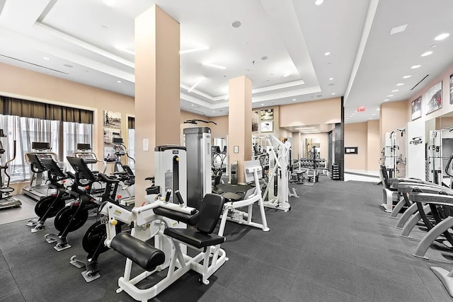 gym with a raised ceiling and recessed lighting