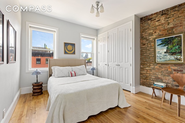 bedroom with light wood finished floors and baseboards