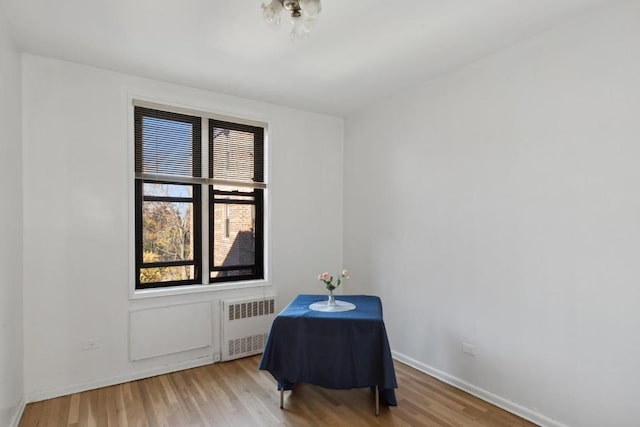 sitting room with hardwood / wood-style flooring and radiator heating unit