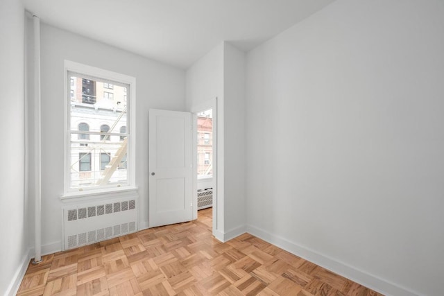 empty room featuring radiator and light parquet floors