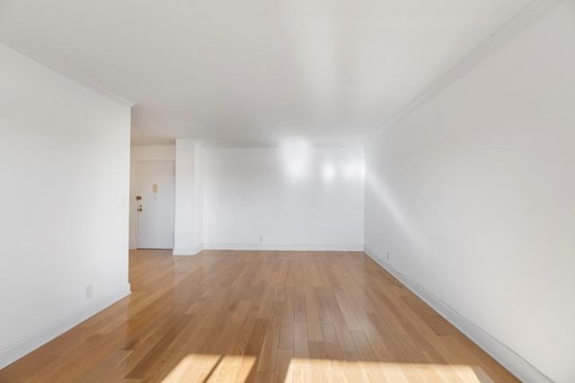 unfurnished room with baseboards and light wood finished floors