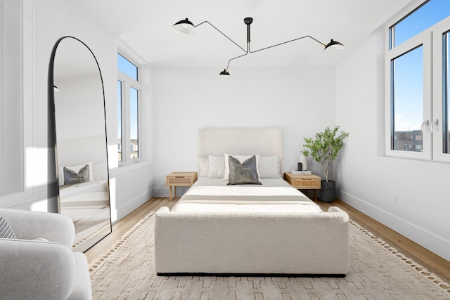 bedroom featuring multiple windows and light wood-type flooring