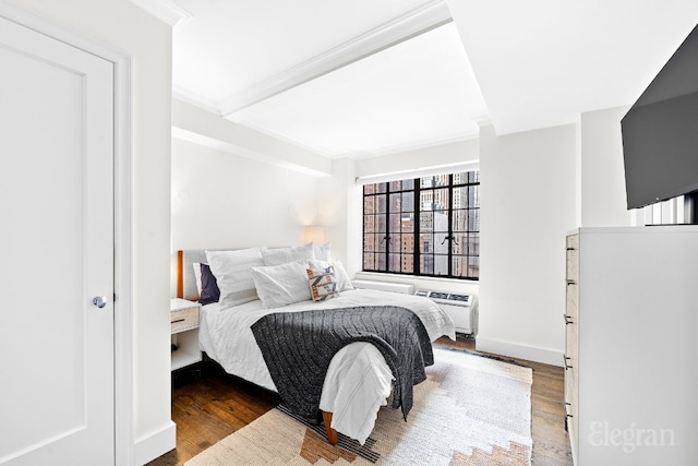 bedroom with hardwood / wood-style floors, crown molding, and a wall unit AC