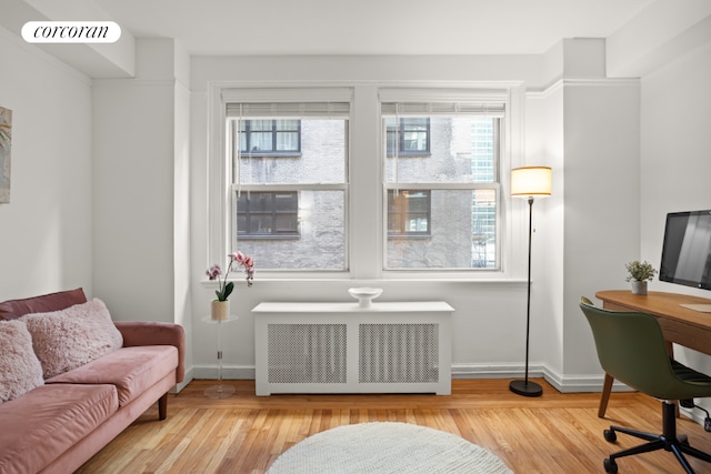 interior space with light wood-type flooring and radiator heating unit