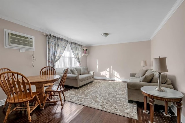 living room featuring a wall unit AC, baseboards, wood-type flooring, and ornamental molding