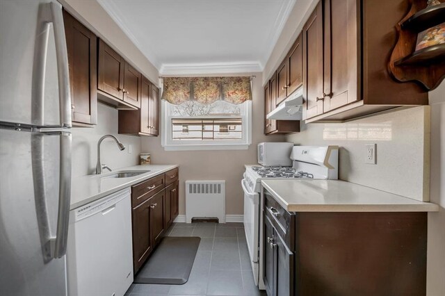 kitchen featuring radiator, light tile patterned flooring, dark brown cabinetry, and white appliances