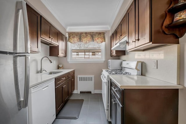 kitchen featuring radiator, light countertops, dark brown cabinetry, white appliances, and under cabinet range hood