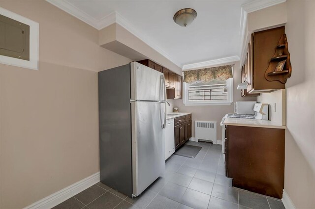 kitchen featuring crown molding, radiator, tile patterned flooring, and white appliances