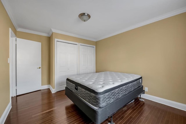 bedroom with crown molding, dark wood-type flooring, and baseboards