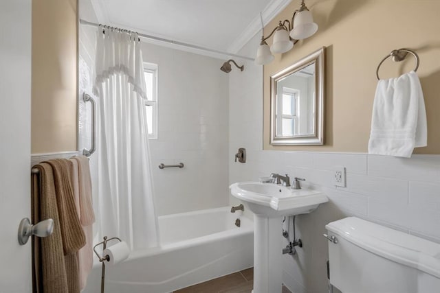 bathroom featuring a healthy amount of sunlight, ornamental molding, tile walls, and shower / bath combination with curtain