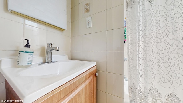 bathroom featuring curtained shower, tile walls, and vanity