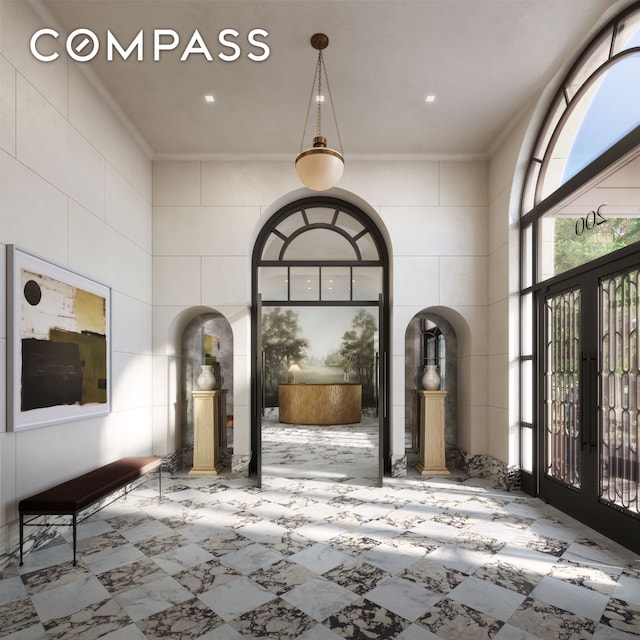 entryway with french doors, a high ceiling, and crown molding