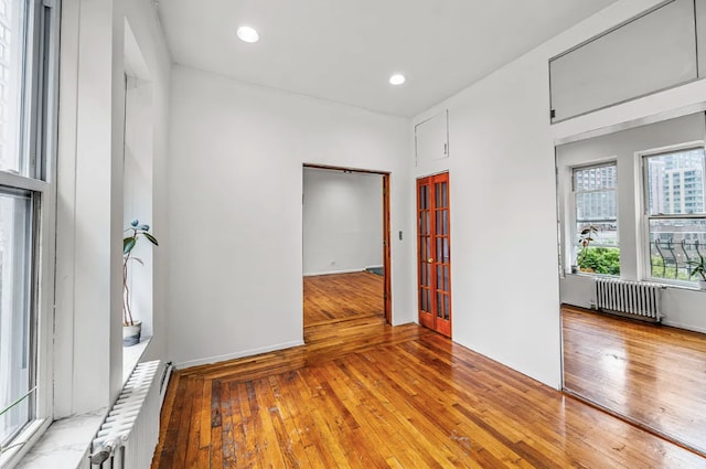 spare room featuring hardwood / wood-style flooring and radiator heating unit