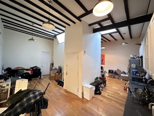 interior space featuring vaulted ceiling with beams and light hardwood / wood-style floors