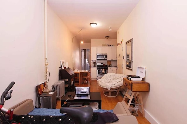 living room with radiator and light hardwood / wood-style flooring