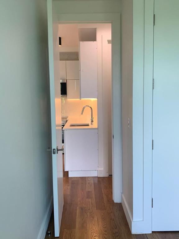 corridor with baseboards, dark wood finished floors, and a sink