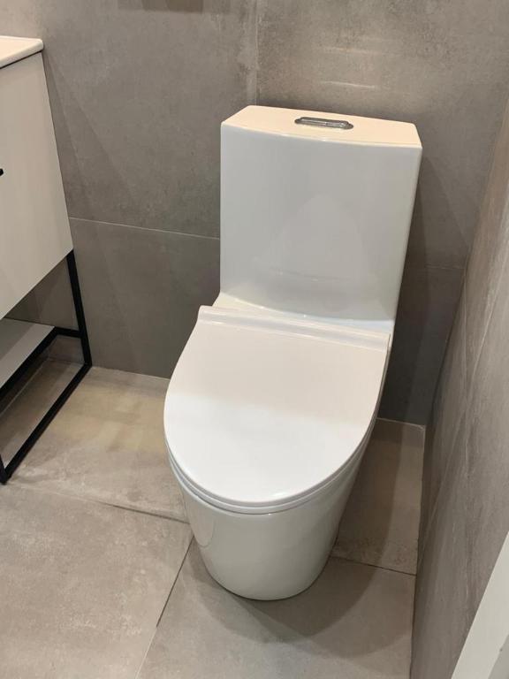 bathroom featuring tile walls, tile patterned flooring, vanity, and toilet