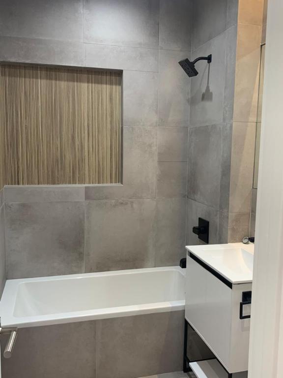 bathroom featuring tiled shower / bath combo and vanity