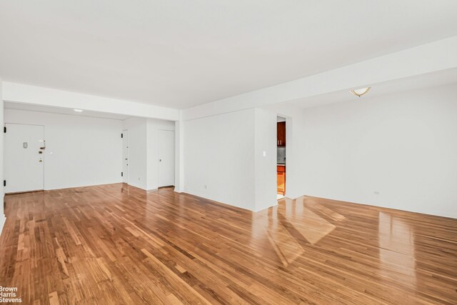 unfurnished living room with wood-type flooring and radiator heating unit