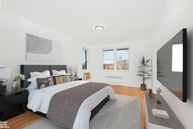 bedroom with radiator and hardwood / wood-style flooring