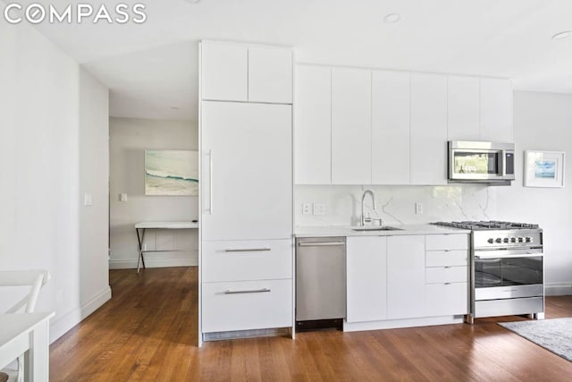 kitchen featuring dark wood-type flooring, sink, white cabinets, and appliances with stainless steel finishes