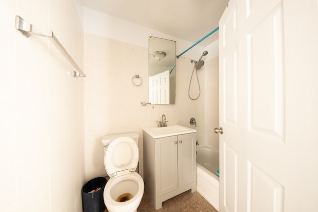 full bathroom featuring toilet, vanity, tile walls, and tub / shower combination