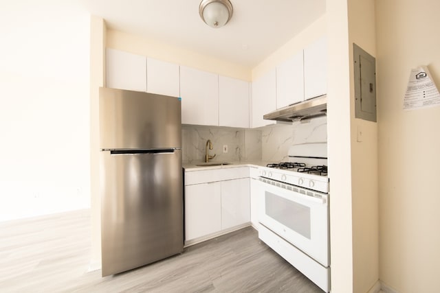 kitchen featuring white cabinetry, tasteful backsplash, stainless steel refrigerator, white gas range oven, and sink