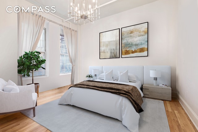 bedroom featuring baseboards, a notable chandelier, and light wood finished floors