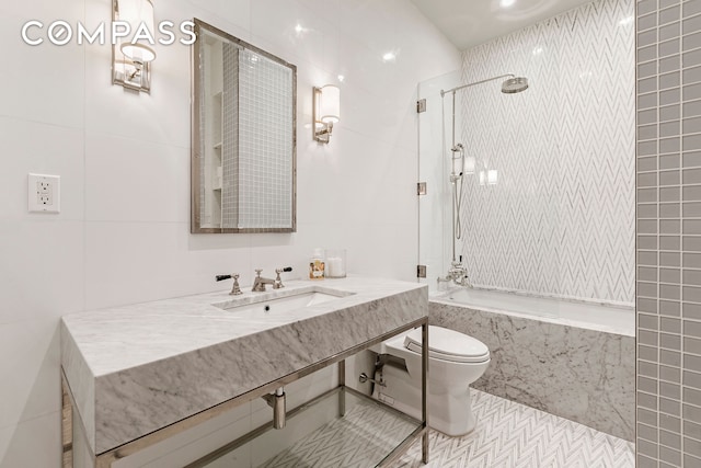 bathroom with a combined bath / shower with marble appearance, toilet, tile patterned floors, a sink, and tile walls