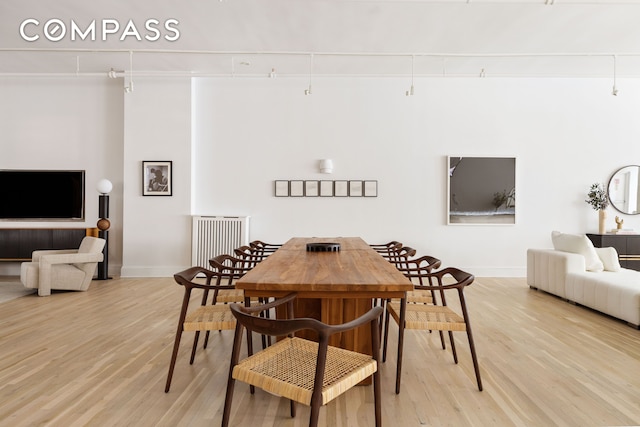 dining area with light wood-type flooring and baseboards