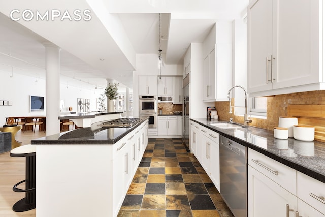 kitchen with tasteful backsplash, a kitchen island, a breakfast bar area, stainless steel appliances, and a sink