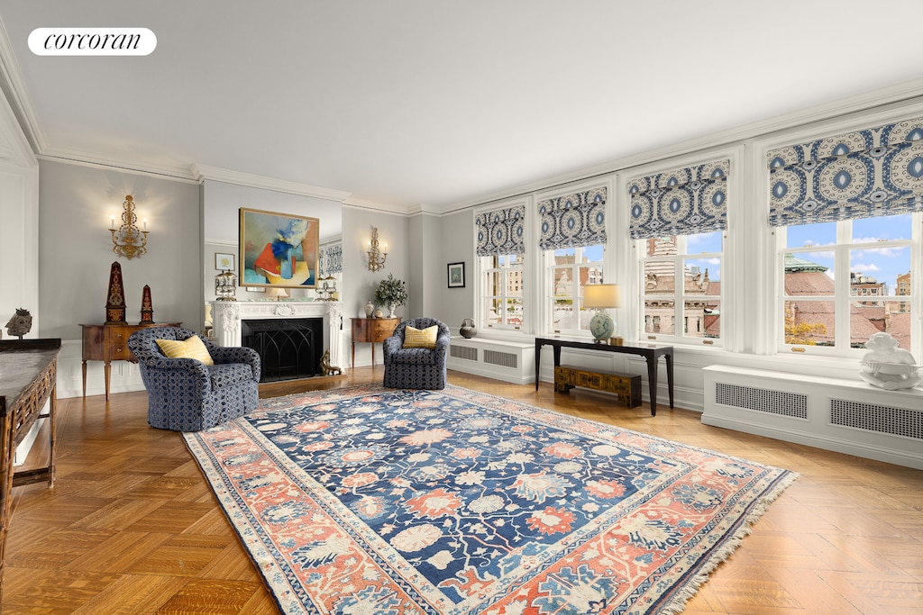 living room featuring radiator, visible vents, crown molding, and a fireplace