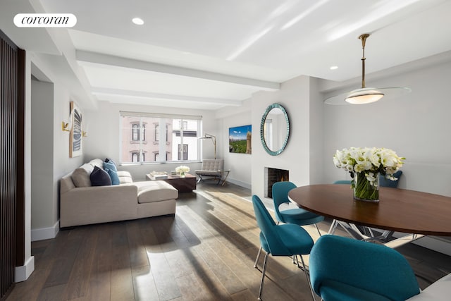 living room with dark wood-type flooring and beamed ceiling