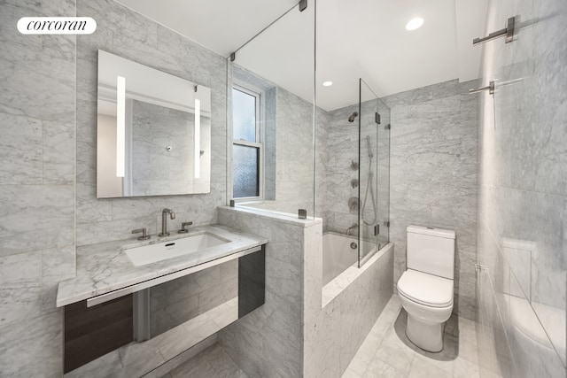 full bathroom with sink, toilet, tile walls, and tiled shower / bath combo