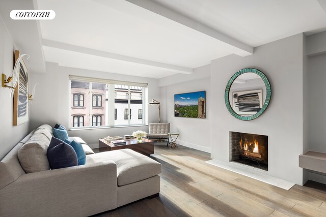 living room with dark wood-type flooring, beamed ceiling, and ceiling fan