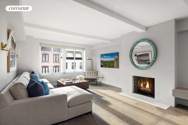 living room featuring beamed ceiling and wood-type flooring