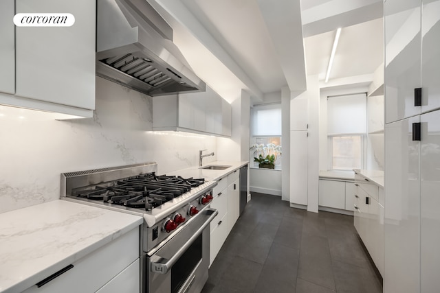 kitchen with white cabinetry, light stone countertops, stainless steel stove, sink, and extractor fan