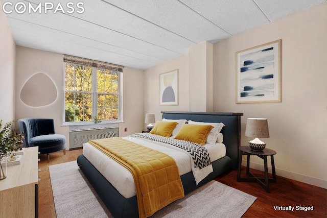 bedroom featuring radiator and hardwood / wood-style floors