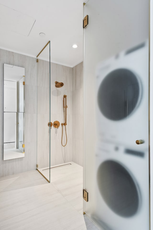 330 Grand St Unit 2A, New York City, NY 10002 - bathroom featuring walk in shower, crown molding, and estacked washer and dryer