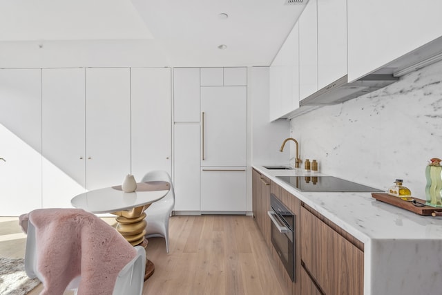 330 Grand St Unit 2A, New York City, NY 10002 - kitchen featuring black appliances, modern cabinets, light wood-style floors, and a sink