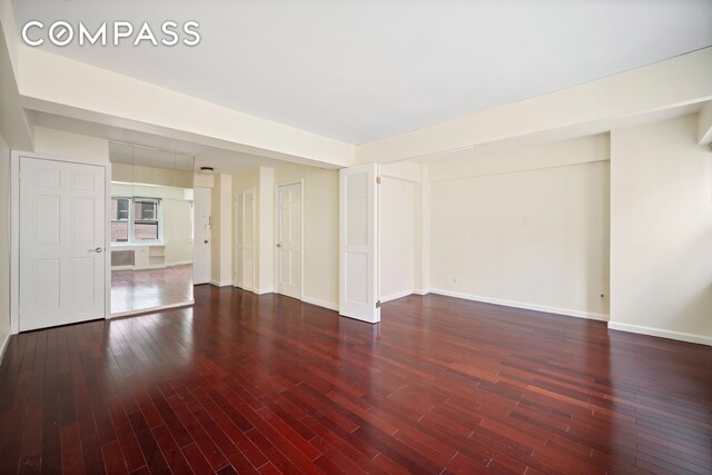 unfurnished room featuring baseboards and wood finished floors