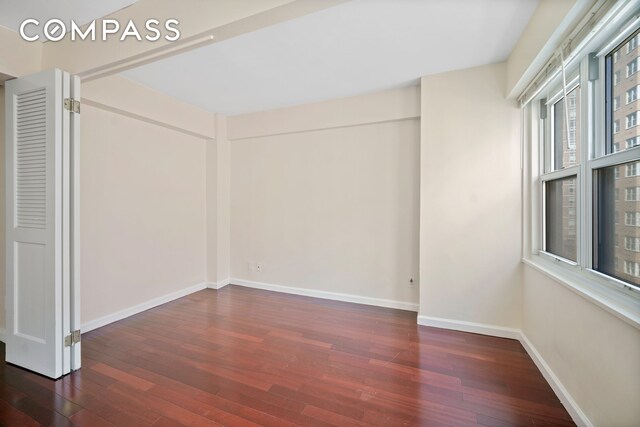 empty room featuring hardwood / wood-style floors and baseboards