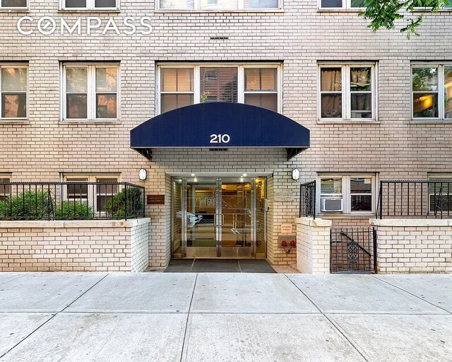 view of exterior entry featuring brick siding