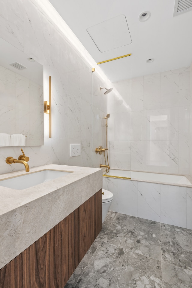 330 Grand St Unit 2B, New York City, NY 10002 - full bathroom with tile walls, vanity, and marble tiled floors