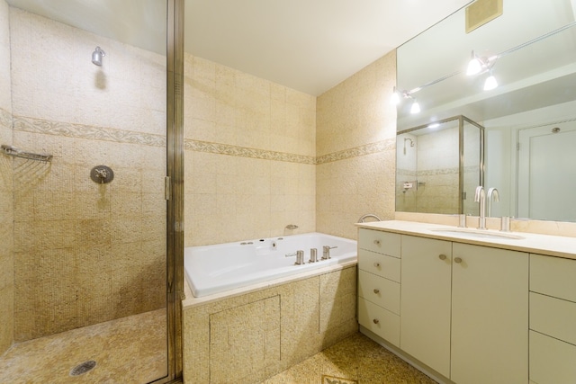 bathroom featuring tile walls, vanity, and plus walk in shower