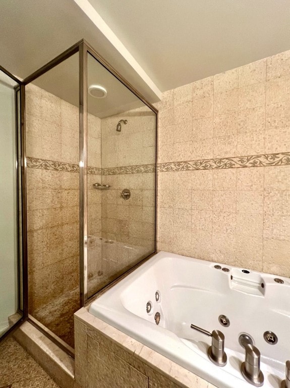 bathroom with tile walls and plus walk in shower