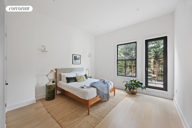 bedroom featuring access to exterior and light hardwood / wood-style flooring