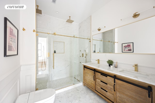 bathroom featuring toilet, vanity, and a shower with shower door